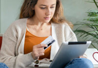young woman using credit card and tablet