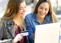 two young women buying online with credit card, financial education