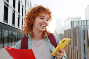 Woman smiling while looking at phone